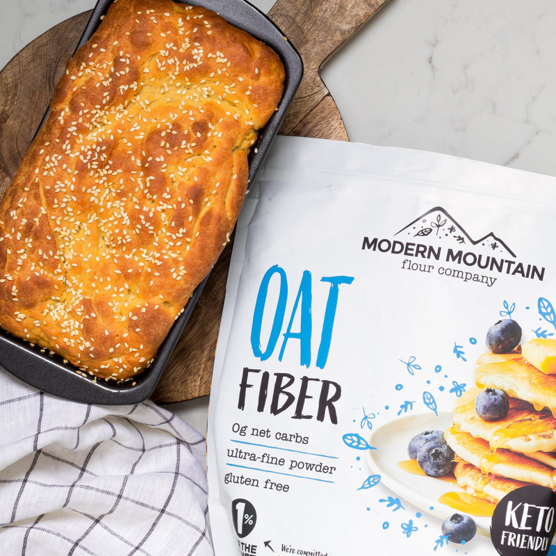 Modern Mountain Oat Fiber pouch beside a fresh-baked low-carb loaf